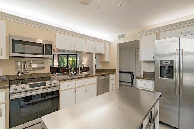 kitchen with a sink, a ceiling fan, appliances with stainless steel finishes, dark countertops, and visible vents