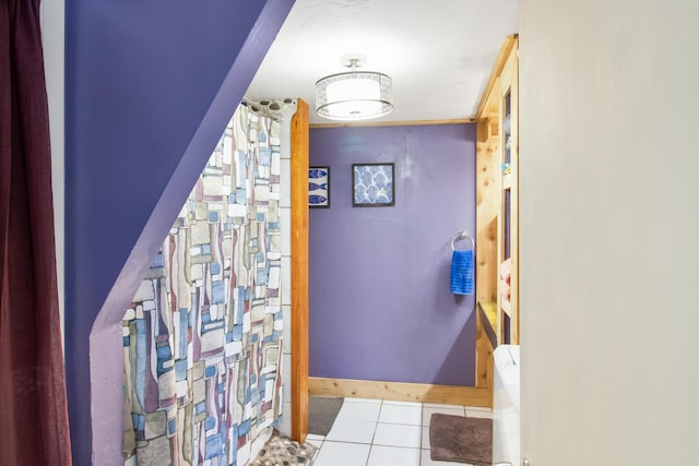 hallway with light tile patterned floors and baseboards