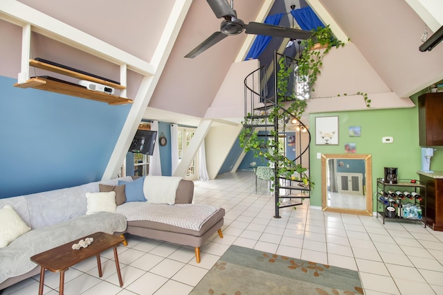 interior space with light tile patterned floors, ceiling fan, stairs, and high vaulted ceiling