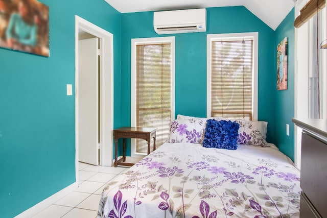 bedroom with light tile patterned floors, a wall mounted AC, and vaulted ceiling