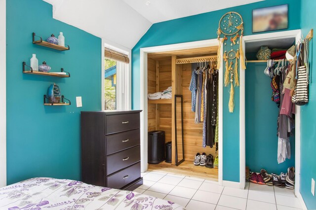 bedroom with lofted ceiling and light tile patterned flooring