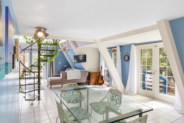 living area featuring light tile patterned floors, french doors, and stairway