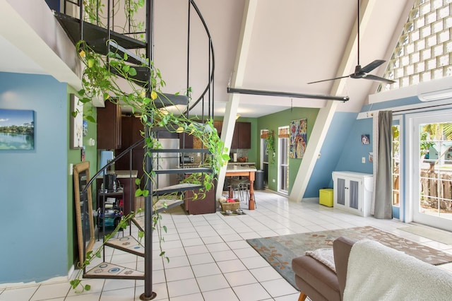 living room featuring a towering ceiling, a ceiling fan, and light tile patterned flooring