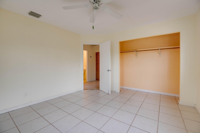 unfurnished bedroom featuring light tile patterned flooring, a closet, visible vents, baseboards, and ceiling fan