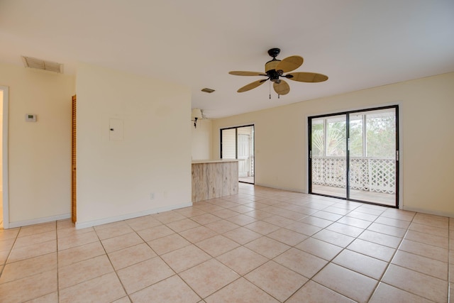 unfurnished room with light tile patterned flooring, baseboards, ceiling fan, and visible vents