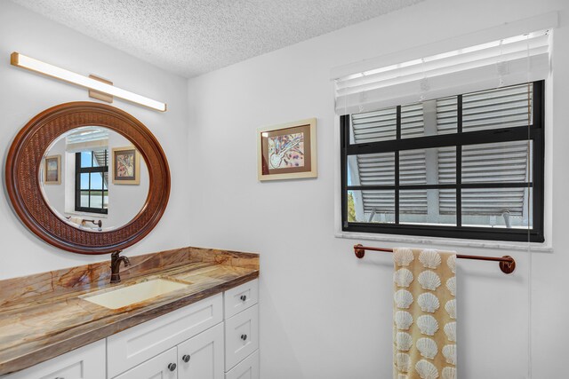 bathroom with a textured ceiling and vanity