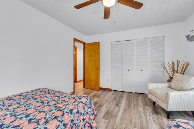 bedroom with light wood-style floors, a closet, baseboards, and a ceiling fan