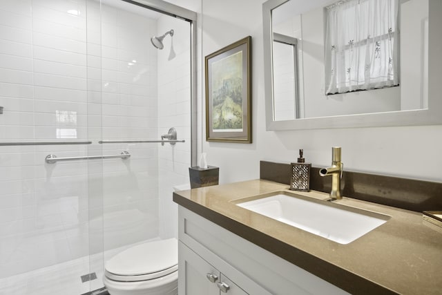 bathroom featuring toilet, a shower stall, and vanity