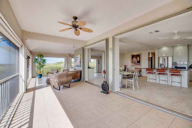 sunroom / solarium with a ceiling fan and visible vents