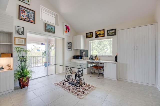 home office with light tile patterned floors, high vaulted ceiling, and a healthy amount of sunlight