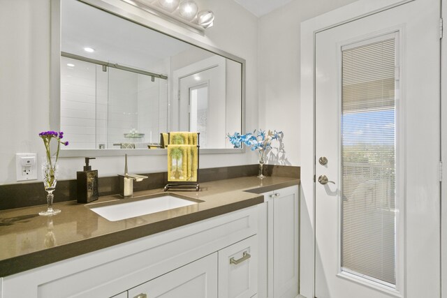 bathroom featuring a shower stall and vanity