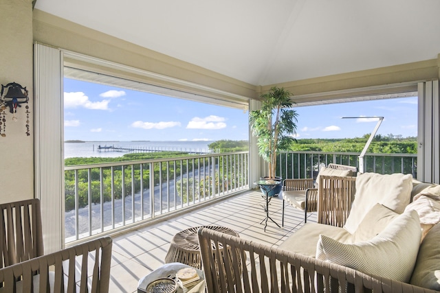 sunroom with vaulted ceiling, a water view, and plenty of natural light