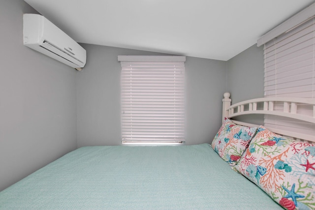 bedroom with a wall mounted AC and vaulted ceiling