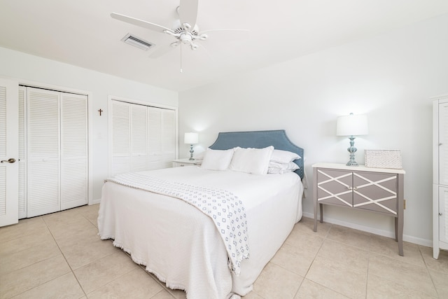 661 12th St, Key Colony, FL 33051 - bedroom featuring two closets, light tile patterned floors, baseboards, and ceiling fan