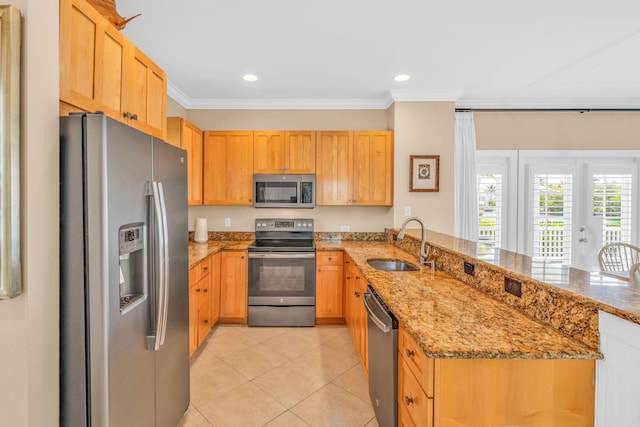 kitchen featuring a peninsula, stainless steel appliances, crown molding, and a sink