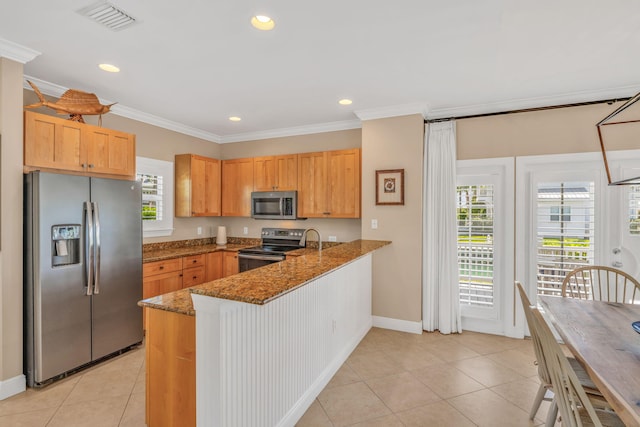 kitchen featuring visible vents, crown molding, dark stone countertops, appliances with stainless steel finishes, and a peninsula