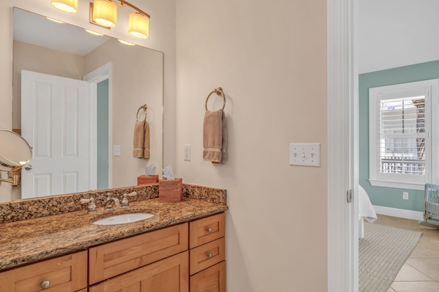 bathroom with tile patterned floors, baseboards, and vanity