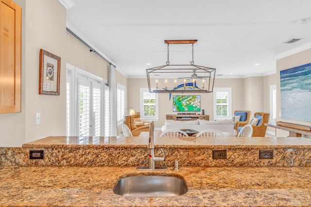 kitchen with ornamental molding, visible vents, open floor plan, and a sink