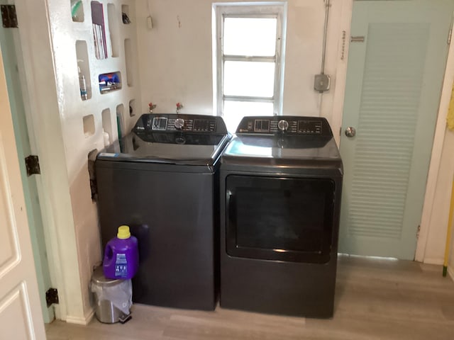 laundry room with laundry area, independent washer and dryer, and wood finished floors