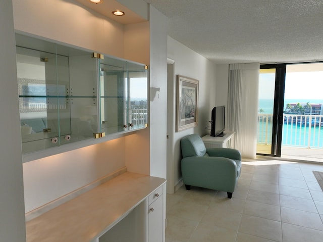 living area featuring recessed lighting, floor to ceiling windows, a textured ceiling, and light tile patterned flooring