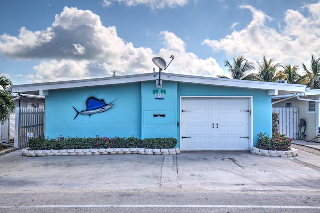 8 Sadowski Cswy, Key Colony, FL 33051 - view of front facade with stucco siding, a garage, and driveway