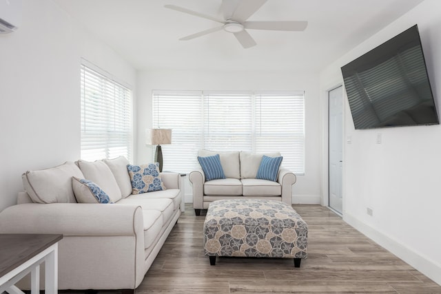 living room with baseboards, light wood-style flooring, and ceiling fan