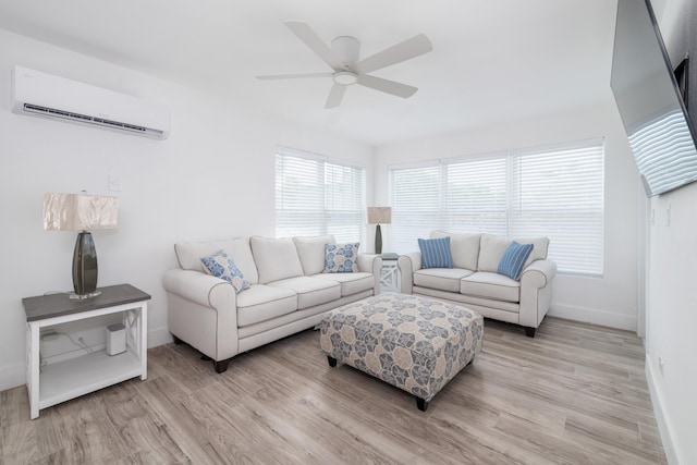 living room with light wood-style floors, baseboards, ceiling fan, and a wall mounted AC
