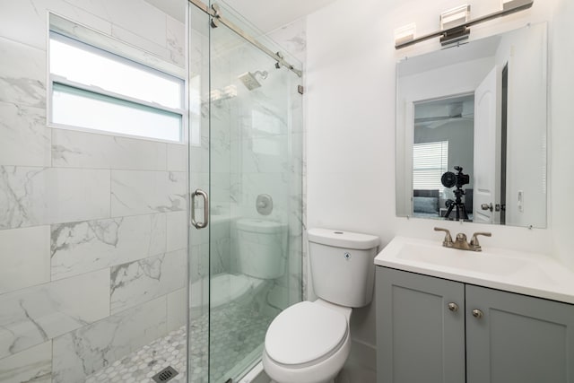 full bath featuring toilet, a shower stall, and vanity