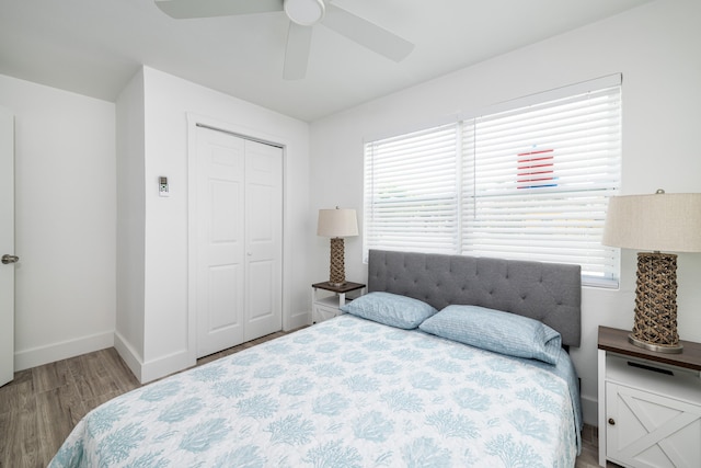 bedroom with a closet, a ceiling fan, baseboards, and wood finished floors