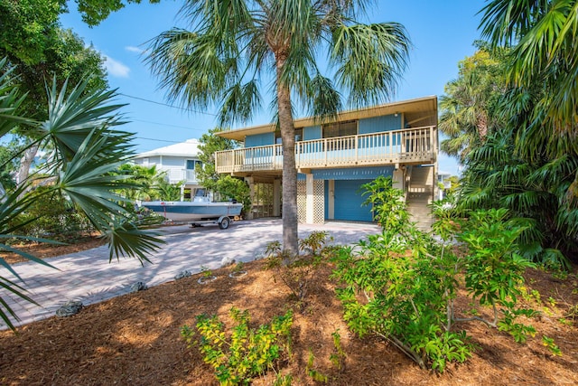 view of front of house with driveway and a balcony