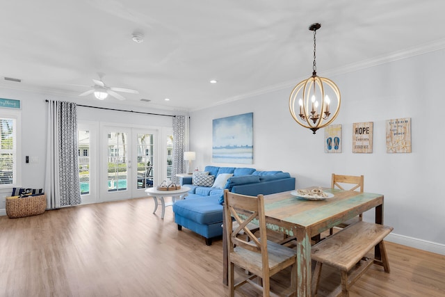 12399 Overseas Hwy Unit 12, Marathon, FL 33050 - dining area featuring crown molding, visible vents, light wood finished floors, and ceiling fan with notable chandelier