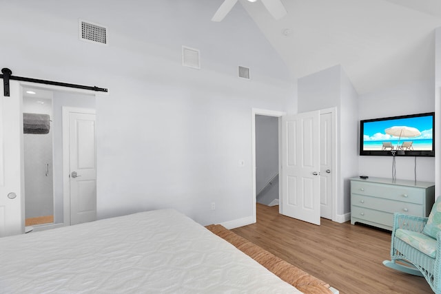 12399 Overseas Hwy Unit 12, Marathon, FL 33050 - bedroom featuring wood finished floors, visible vents, high vaulted ceiling, and a barn door