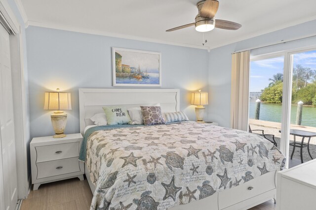 1215 97th St Unit 2, Marathon, FL 33050 - bedroom with ornamental molding, access to exterior, a water view, a ceiling fan, and wood finished floors