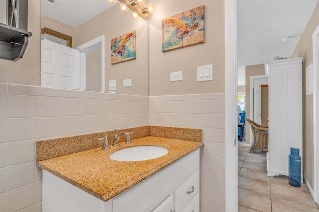 bathroom with tile walls, tile patterned flooring, and vanity