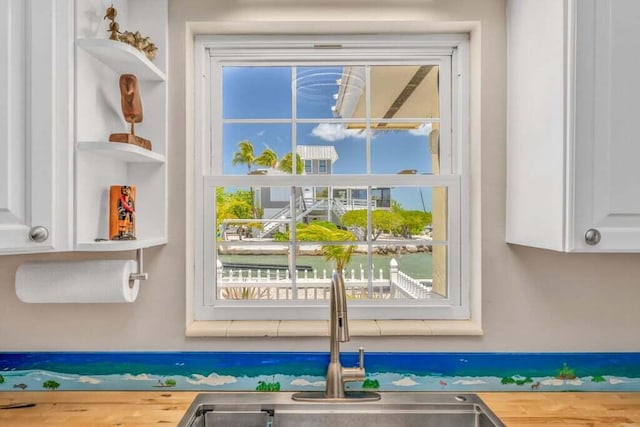 interior details with a sink and white cabinetry