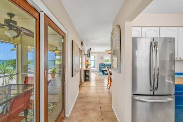 hall with baseboards and light tile patterned floors