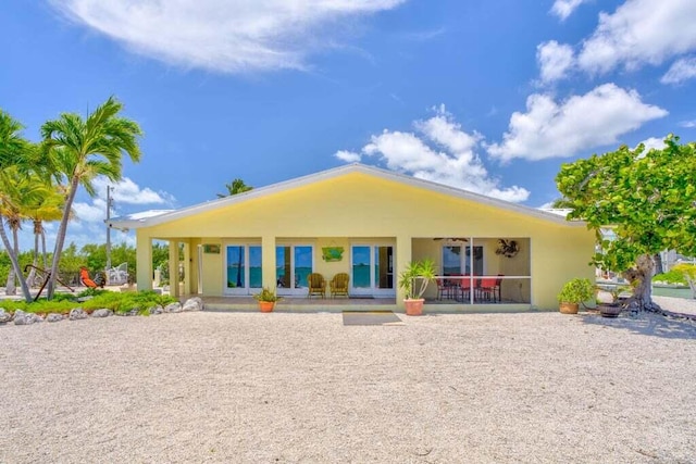 rear view of property featuring a patio, ceiling fan, and stucco siding