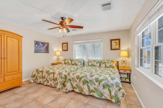 bedroom featuring visible vents, a ceiling fan, baseboards, and light tile patterned flooring