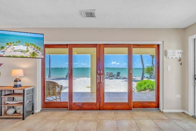 doorway to outside featuring tile patterned flooring, a textured ceiling, french doors, baseboards, and visible vents