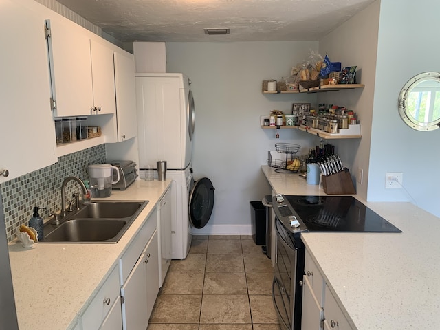 109 Stirrup Key Woods Rd Unit 1B2, Marathon, FL 33050 - kitchen featuring electric range oven, a sink, stacked washer and clothes dryer, white cabinets, and light tile patterned floors