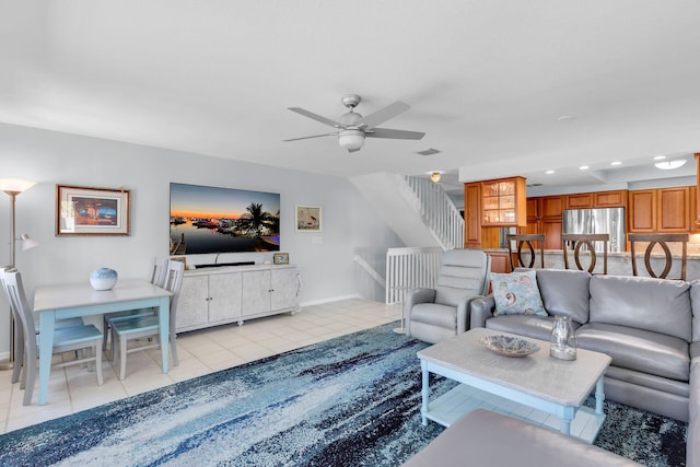 living room with visible vents, stairway, light tile patterned flooring, ceiling fan, and baseboards