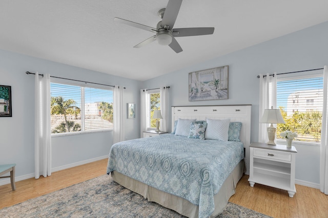 bedroom featuring vaulted ceiling, light wood-style flooring, and baseboards