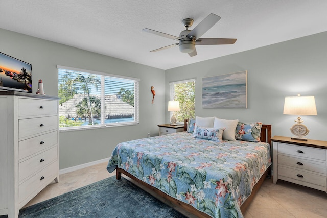 bedroom with a textured ceiling, a ceiling fan, and baseboards