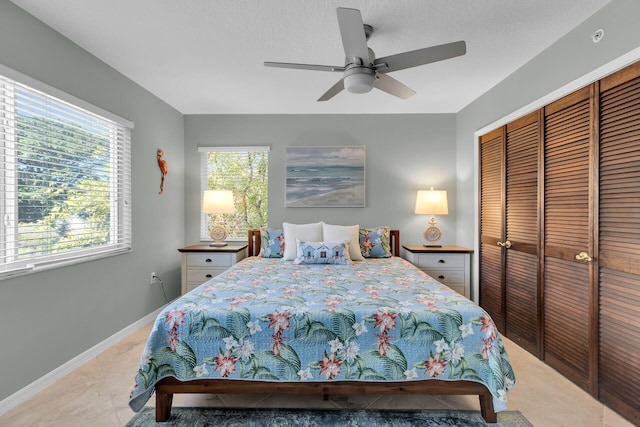 bedroom with a ceiling fan, a textured ceiling, baseboards, and a closet