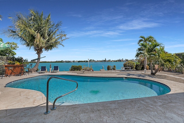 pool with a water view, a patio area, and an outdoor bar