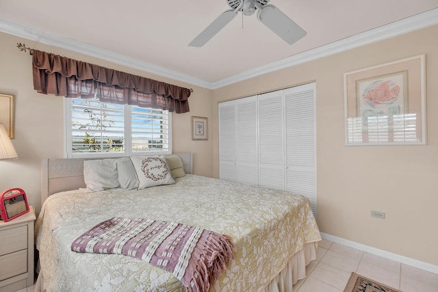 bedroom featuring light tile patterned floors, baseboards, ceiling fan, crown molding, and a closet