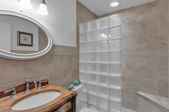 full bathroom featuring toilet, tile walls, and vanity