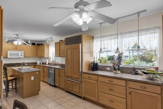 kitchen with a breakfast bar, a center island, white microwave, a sink, and dishwasher