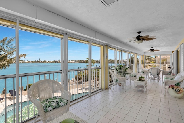 unfurnished sunroom with a water view and ceiling fan