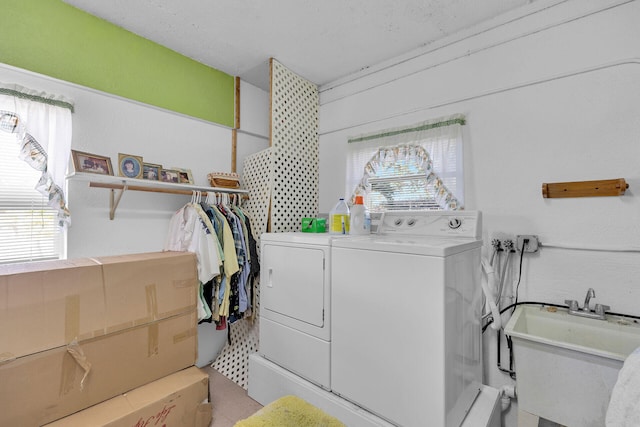 laundry area with laundry area, separate washer and dryer, and a sink